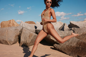 Model is wearing Akosha's drama one-piece bathing suit in cheetah print. Swimsuit features a deep-v neckline and criss cross back and is reversible to Akosha's Bali fabric print. Swimsuit is made out of Akosha's luxurious ribbed fabric and is made in the USA.
